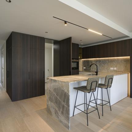 Leefkeuken in natuursteen met warme accenten en toegang tot de berging via de kastenwand - deel 02