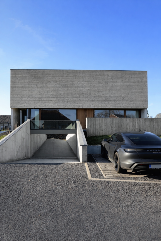 Brutalische villa in plankenbekist zichtbeton & spiegelende garagepoort