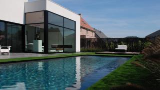 moderne villa in crepi met grote glaspartijen achteraan