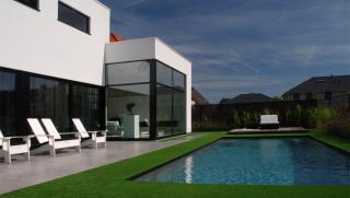 moderne villa in crepi met grote glaspartijen achteraan