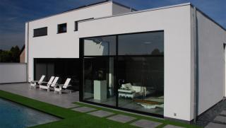moderne villa in crepi met grote glaspartijen achteraan